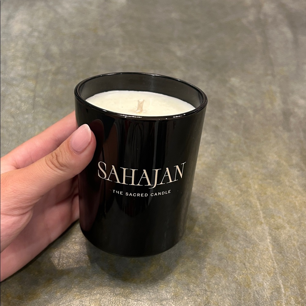 Sahajan "The Sacred Candle" in a black glass vessel.